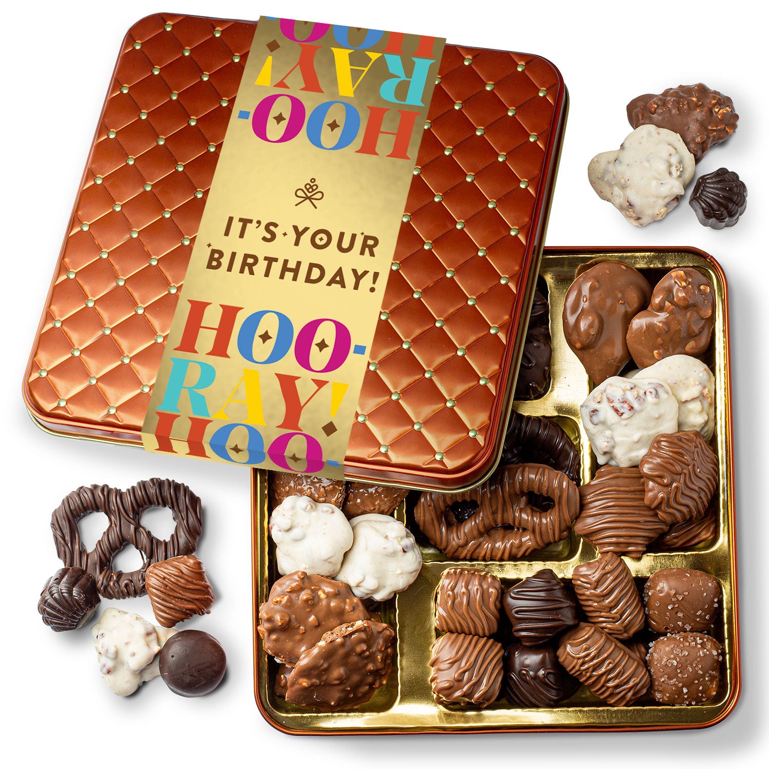 A collection of assorted chocolates presented in a square tin container with a birthday greeting on the lid.