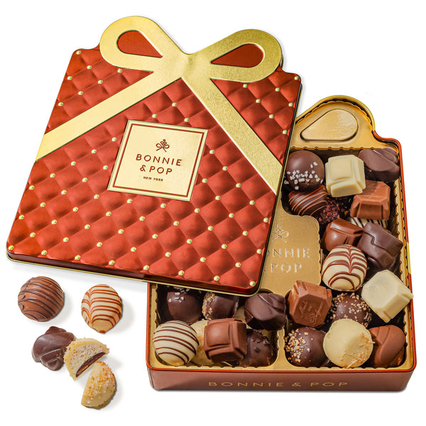 An elegant copper and gold quilted gift tin from Bonnie & Pop with an assortment of handcrafted Belgian chocolate truffles displayed inside.
