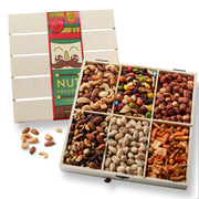 A wooden gift box containing various types of gourmet nuts in sections, with a festive Nutcracker holiday sleeve on the lid.